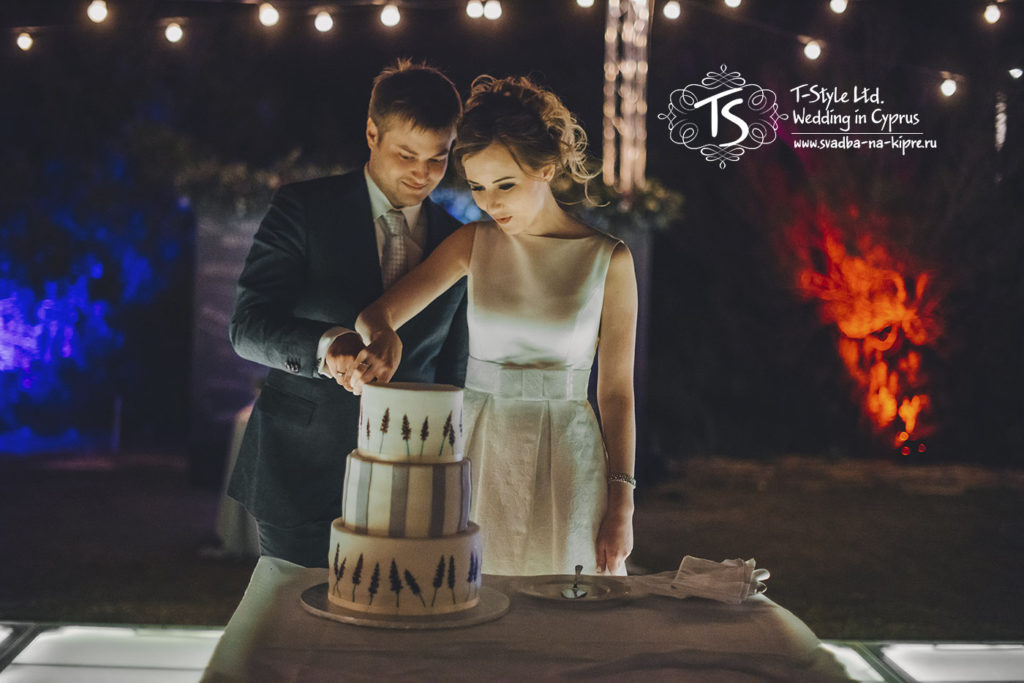 Жених и невеста разрезают свадебный торт на Кипре